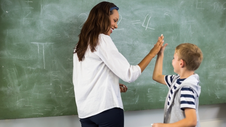 Image of a teacher giving her student a high five